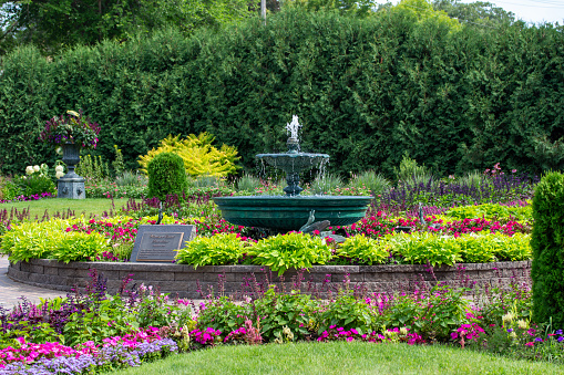 St. Cloud, Minnesota, USA - July 25, 2023: Landscape view of the beautiful Clemens Formal Garden, featuring the Windsor Court Fountain, near the Mississippi River in St. Cloud.