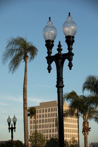A historic street light frames a view of the downtown skyline of Santa Ana, California, USA.