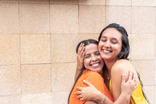 istock Two friends embracing in the city 1664710536