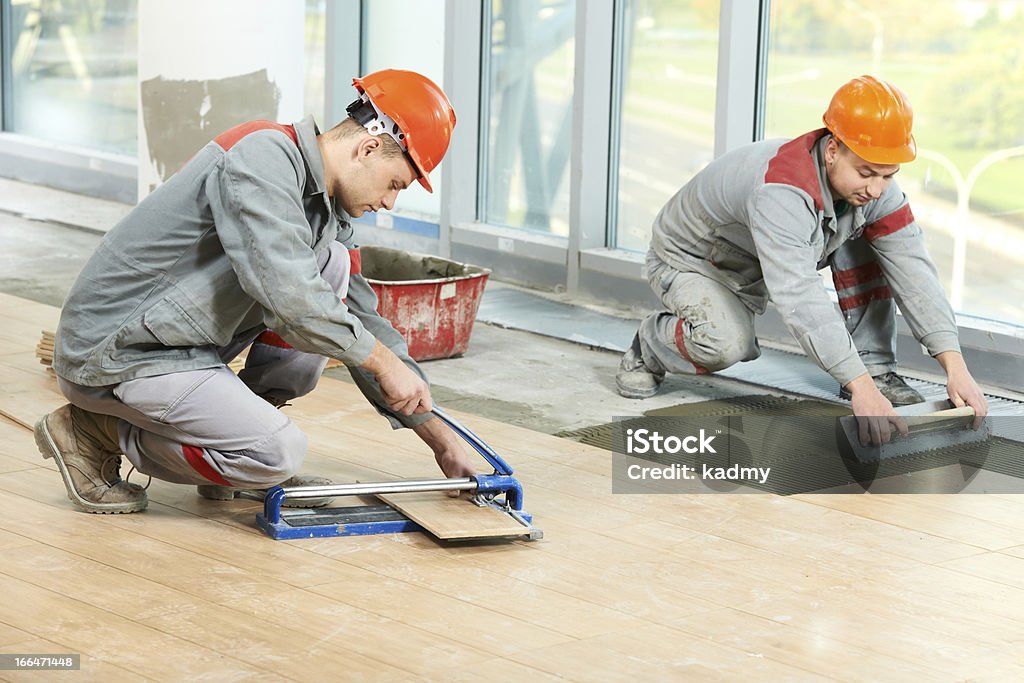 Dois tilers no piso industrial tiling renovação - Royalty-free Instalar Foto de stock