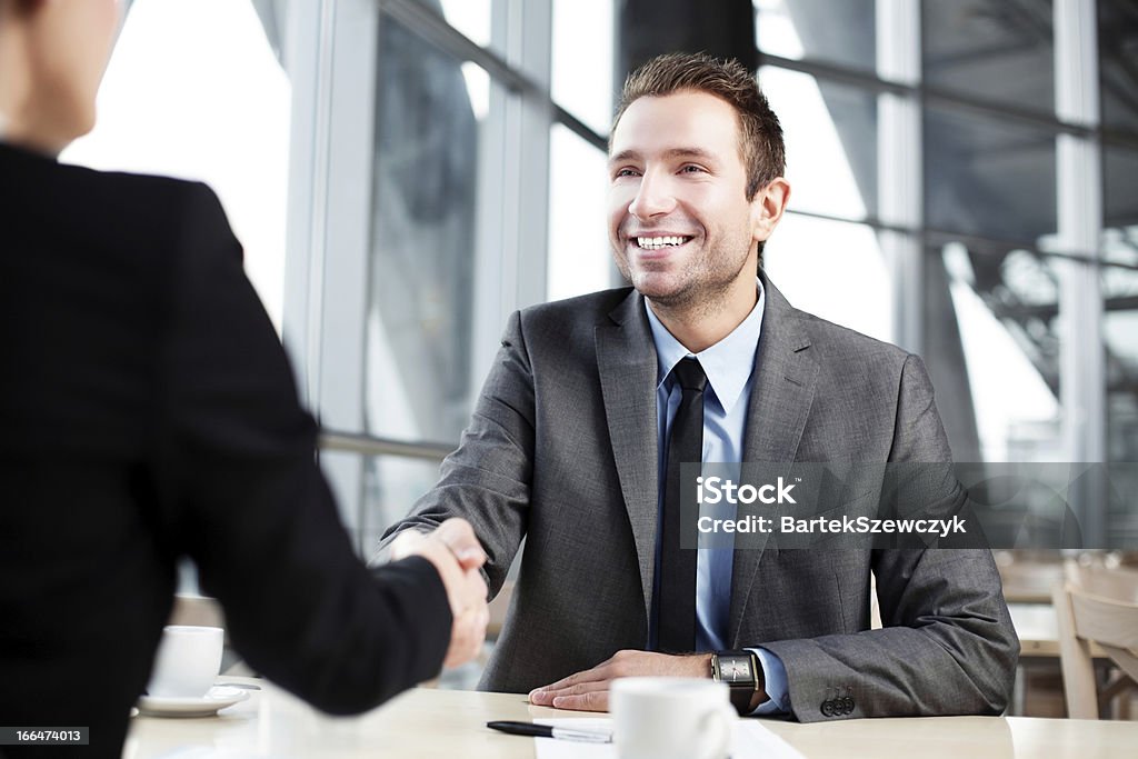 Business Handshake Happy businessman shaking hand with businesswoman. Gripping Stock Photo