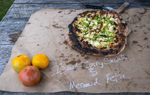 A top view freshly prepared wood fire pizza on a wooden table