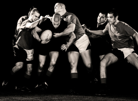 Black and white photo of rugby players in action. Isolated on black.   