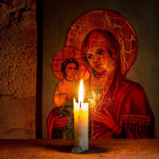 istock A lit candle against the background of an ancient religious icon. 1664843486