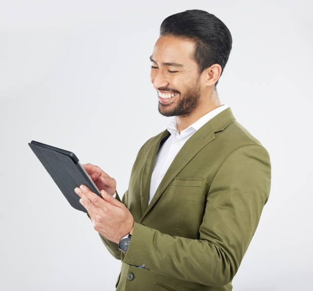 istock Smile, tablet and happy businessman search internet on technology isolated in a studio white background. Online, planning and young person or employee working on connection or networking on app 1664876834