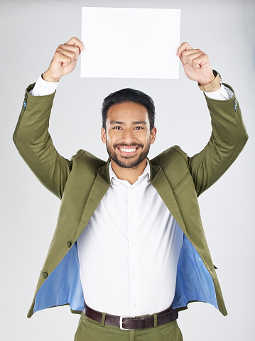 Happy asian man, portrait and billboard in advertising, marketing or branding against a white studio background. Businessman smile with paper, poster or sign for message or advertisement on mockup