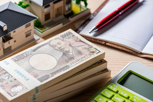 Stack of Bills and Miniature House Model