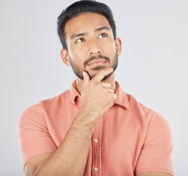 istock Thinking, face and asian man in studio for planning, choice or questions on grey background space. Idea, why and Japanese male model confused by decision, brainstorming or problem solving doubt emoji 1664886898