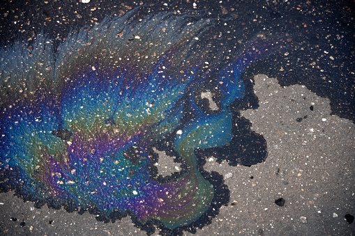 Gasoline or oil spill, rainbow stains on asphalt