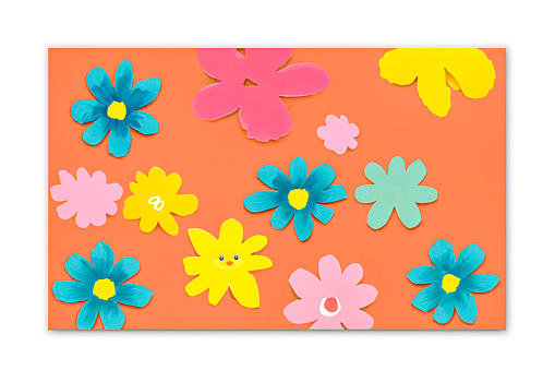 The picture shows colorful paper cut into flower shapes to make art on a kindergarten student's art coloring book.