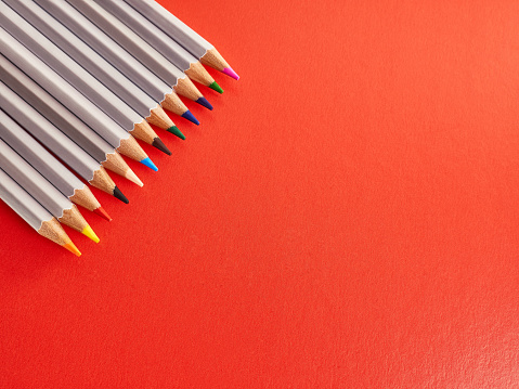 A set of colored pencils on a red background. Stationery for creativity and learning.