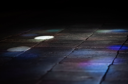 The vibrant colors of light reflecting off the floor of a dark and mysterious church interior