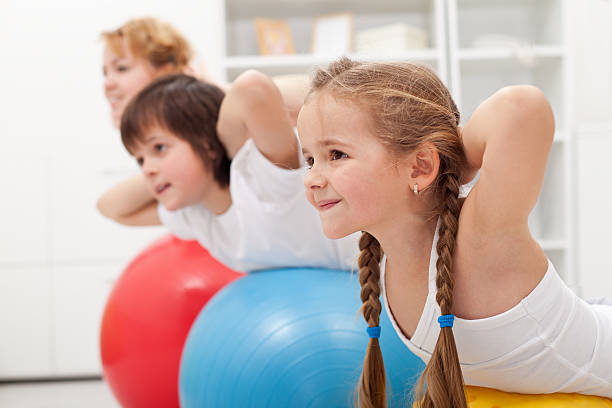 istock Kids and woman doing exercises with balls 166493509
