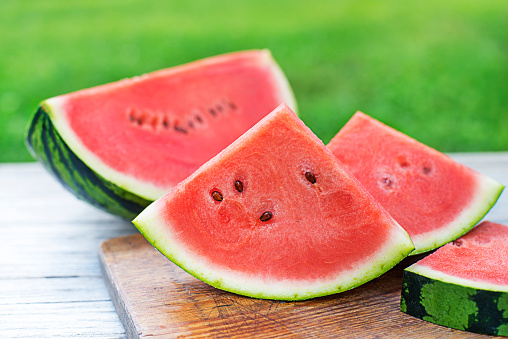 Fresh sliced watermelon in wooden table background outdoors