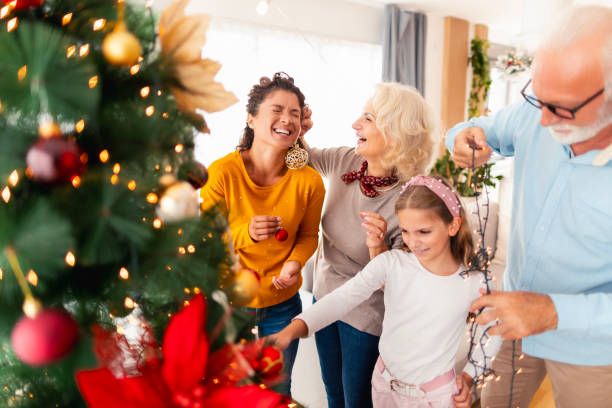 istock Happy family decorating Christmas tree 1664997653