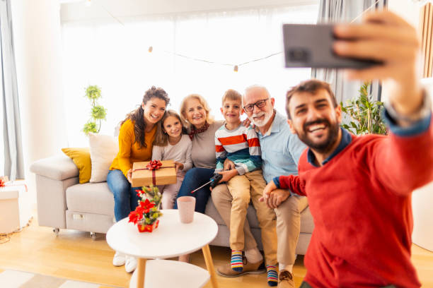 Multi-generation family taking selfie while celebrating Christmas at home stock photo