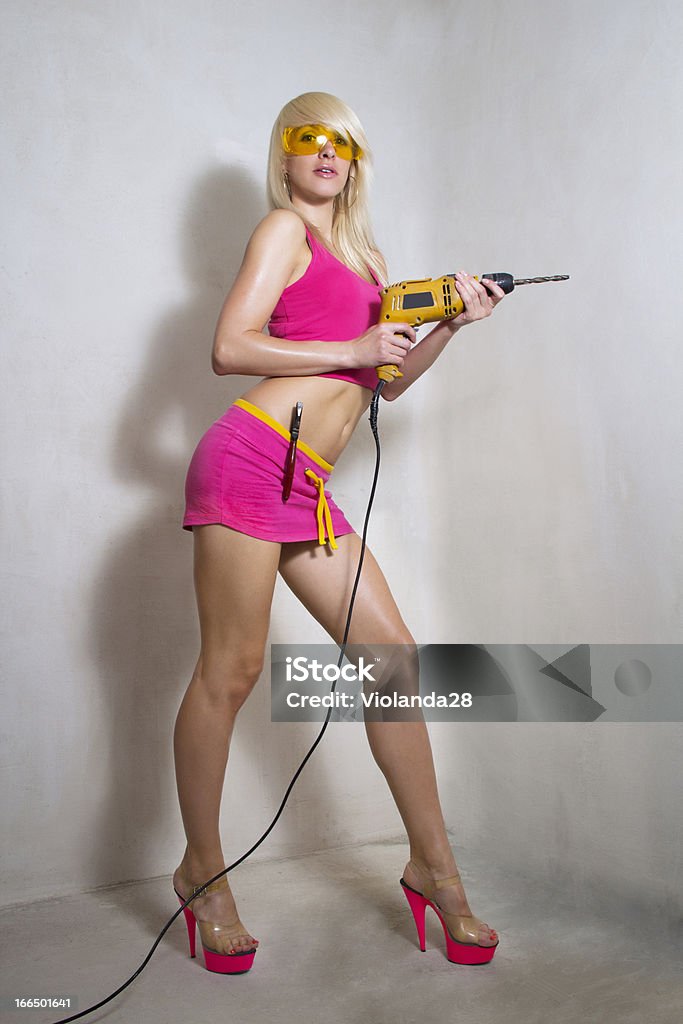 Sexy Chica sosteniendo un taladro - Foto de stock de Actividad libre de derechos