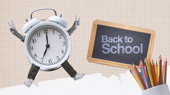 Back to school: happy alarm clock character jumping and school supplies