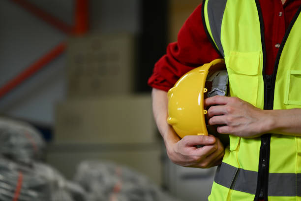 istock Unrecognizable warehouse worker wearing security vest standing near the stack of cardboard boxes 1665026944