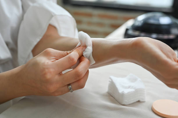 istock Young woman using cotton pads cleaning liquid lipsticks on her hand with micellar water 1665027982