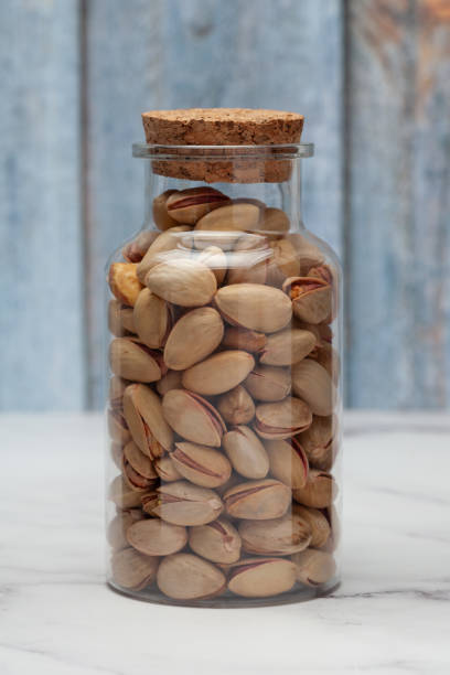istock Fresh salted Pistachio nuts into a glass jar with a closed lid. 1665034430