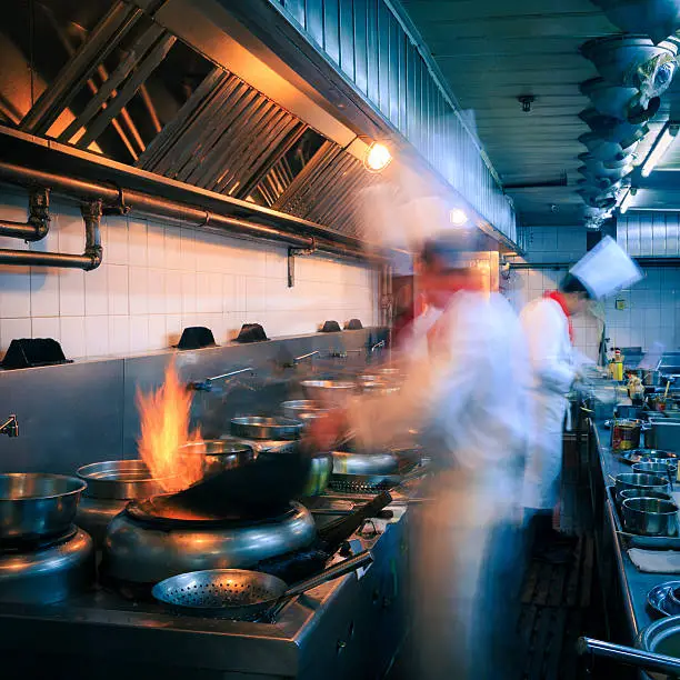 Photo of Interior of a restaurant kitchen with busy chefs