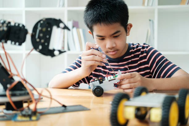 istock Asian teenager doing robot project in science classroom. technology of robotics programing and STEM education concept. 1665074658
