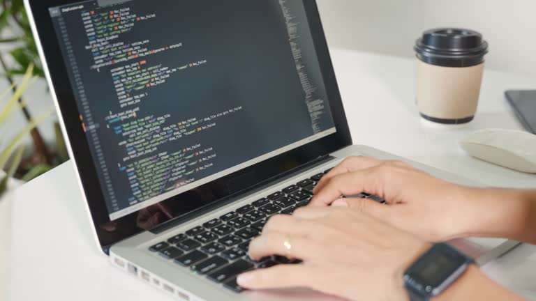 Programmer woman writing program HTML code sitting at workplace in office