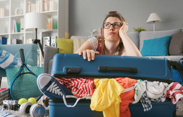 istock Exhausted sad woman packing her luggage 1665108981