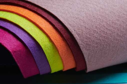 Multi-colored soft felt textile material, colorful patchwork texture fabric close-up