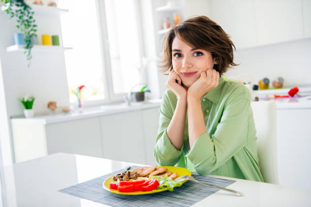 예쁜 매력적인 소녀의 사진은 아침 식사를 즐기는 녹색 셔츠를 입고 팔, 뺨, 광대뼈, 실내 부엌 방 - stereotypical housewife women domestic kitchen brown hair 뉴스 사진 이미지