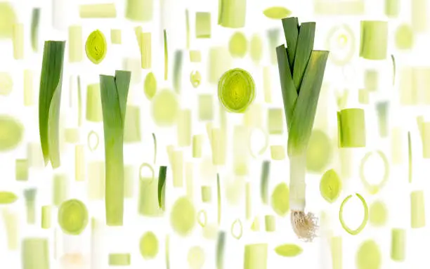Abstract background made of Leek vegetable pieces, slices and leaves isolated on white.
