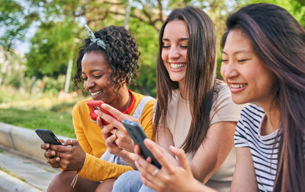 istock Three smiling young women using cell phone outdoors. Group of happy friends checking social networks 1665130491