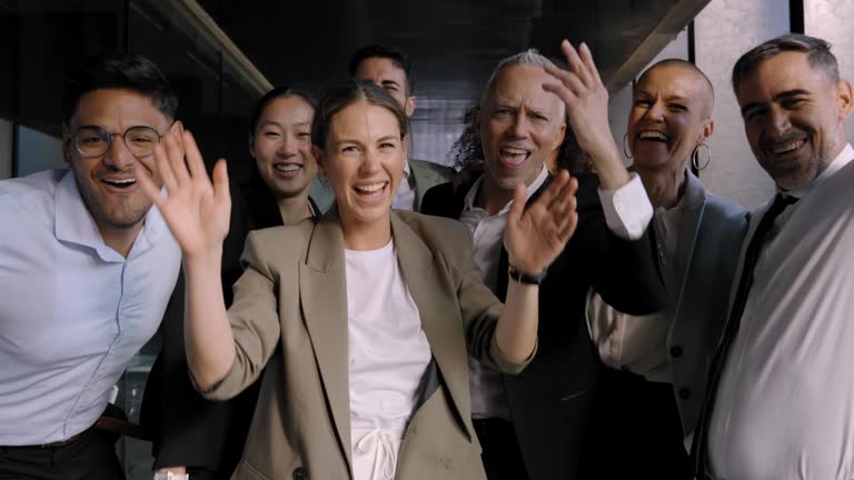 Excited funny multi-ethnic staff people business team stand in office looking at camera.