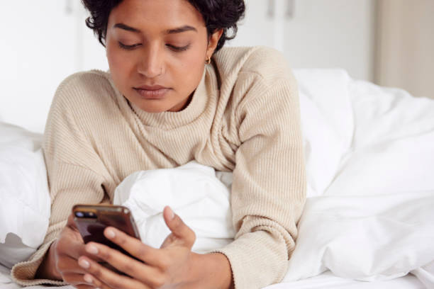 istock Morning Routine: Woman in Bed with Phone 1665142803