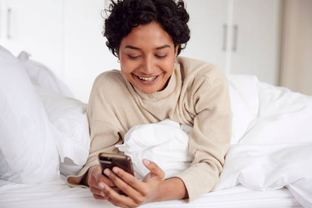 istock Morning Routine: Woman in Bed with Phone 1665142869