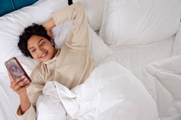 istock Morning Routine: Woman in Bed with Phone 1665144487