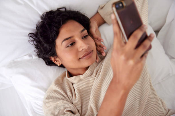 istock Morning Routine: Woman in Bed with Phone 1665146716