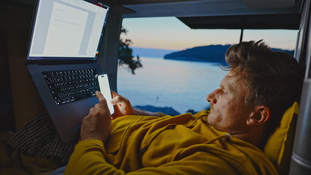 Freelancer working on laptop while reclining in motor home