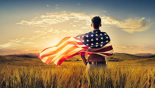 Młody człowiek Zawinięty Amerykańska flaga polu z uprawami słońca – zdjęcie