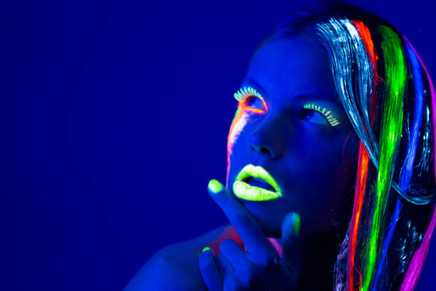 istock Women Portrait with Glowing Multi Colored makeup in black light 166518181