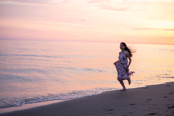 istock Happy woman running at the beach 1665187368