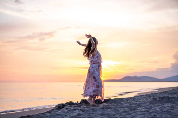 istock Woman whit outstretched hands standing at the beach 1665192700