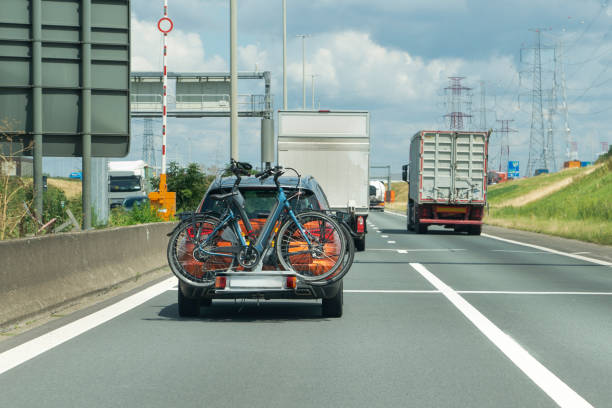 istock Car transports bicycles on a rack on highway 1665199704