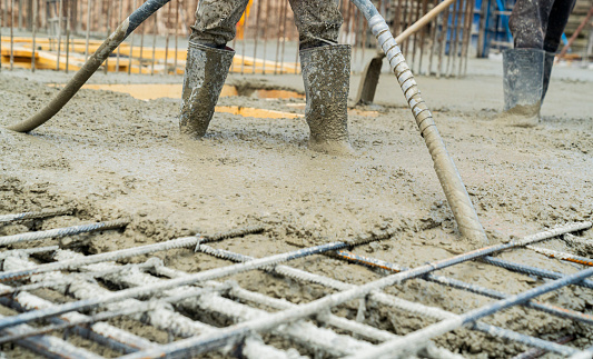 Construction worker Concrete pouring during commercial concreting floors of buildings in construction site and Civil Engineer, Concrete construction and reinforcement