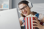 Happy woman watching movies on her laptop