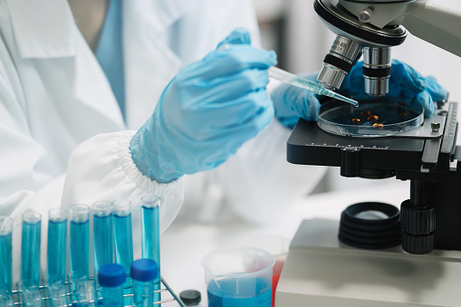 Science and medicine, scientist analyzing and dropping a sample into a glassware, experiments containing chemical liquid in laboratory on glassware, innovative and technology.