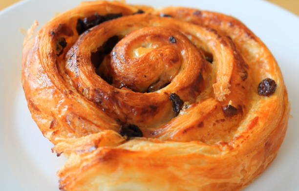 istock Close up beside view of raisin bread on white dish. 1665335994