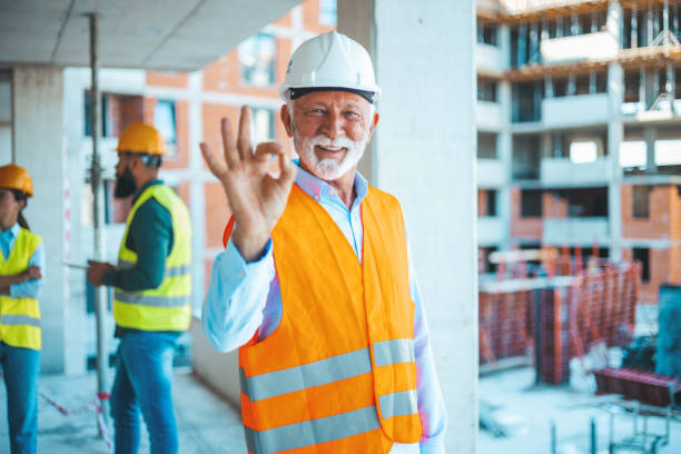 istock Senior architect standing at construction site and showing thumbs up. 1665340276