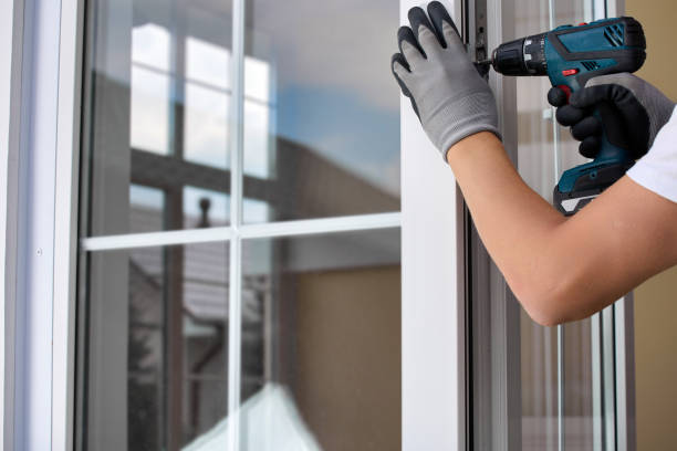 istock Worker's gloved hand with automatic screwdriver screws fastening on plastic door 1665347561